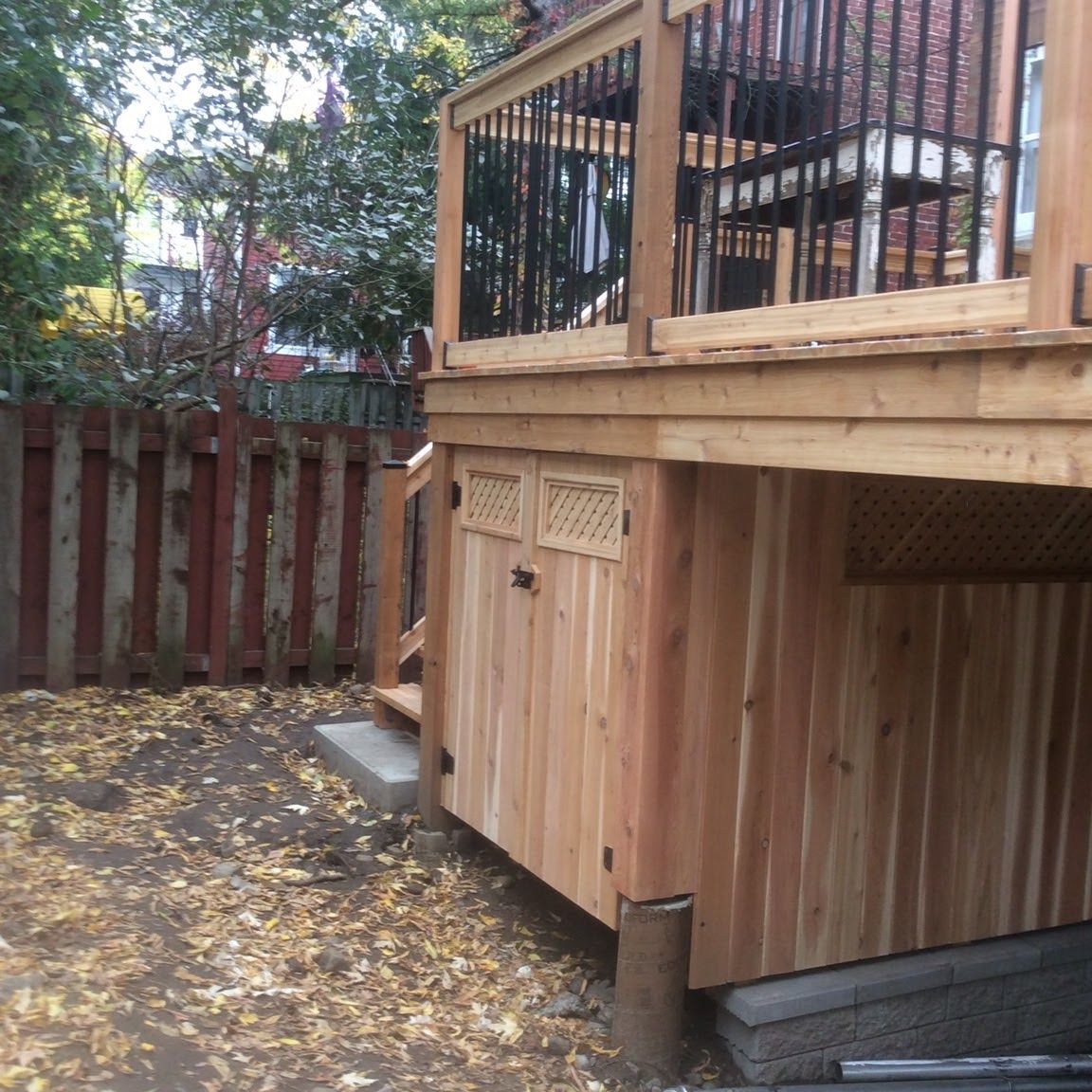 Une terrasse en bois avec une clôture en arrière-plan