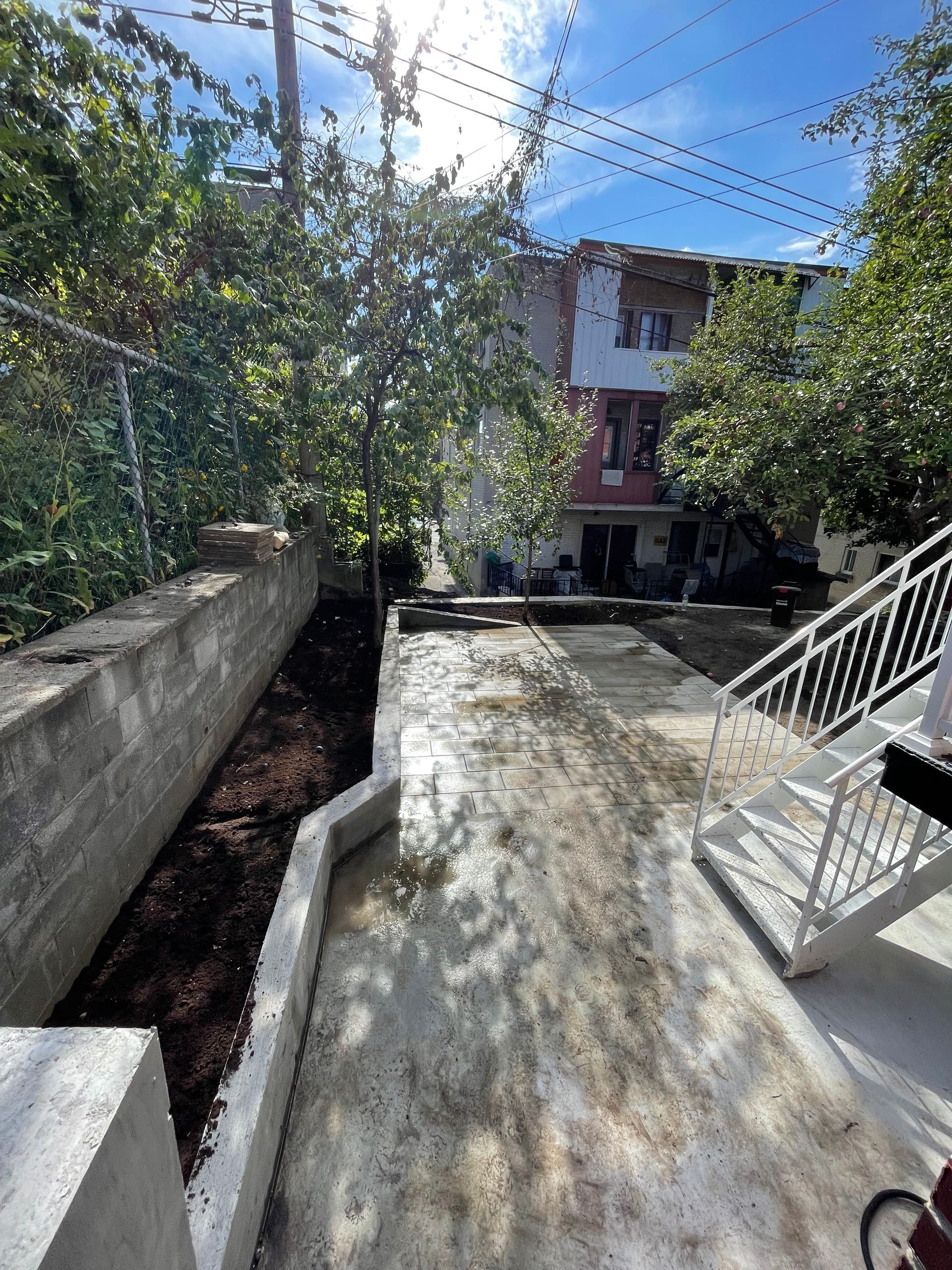 Une allée en béton avec des escaliers menant à une maison.