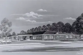 Black-and-white drawing of a low brick building with a parking lot and trees in front.