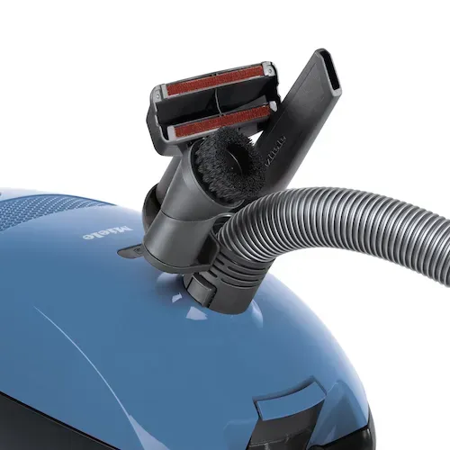 Blue Miele vacuum cleaner with silver hose, wand, and brush head on a white background.