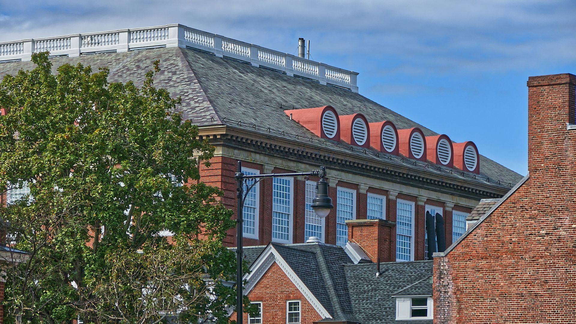 A brick building with a roof that has a red arrow on it.