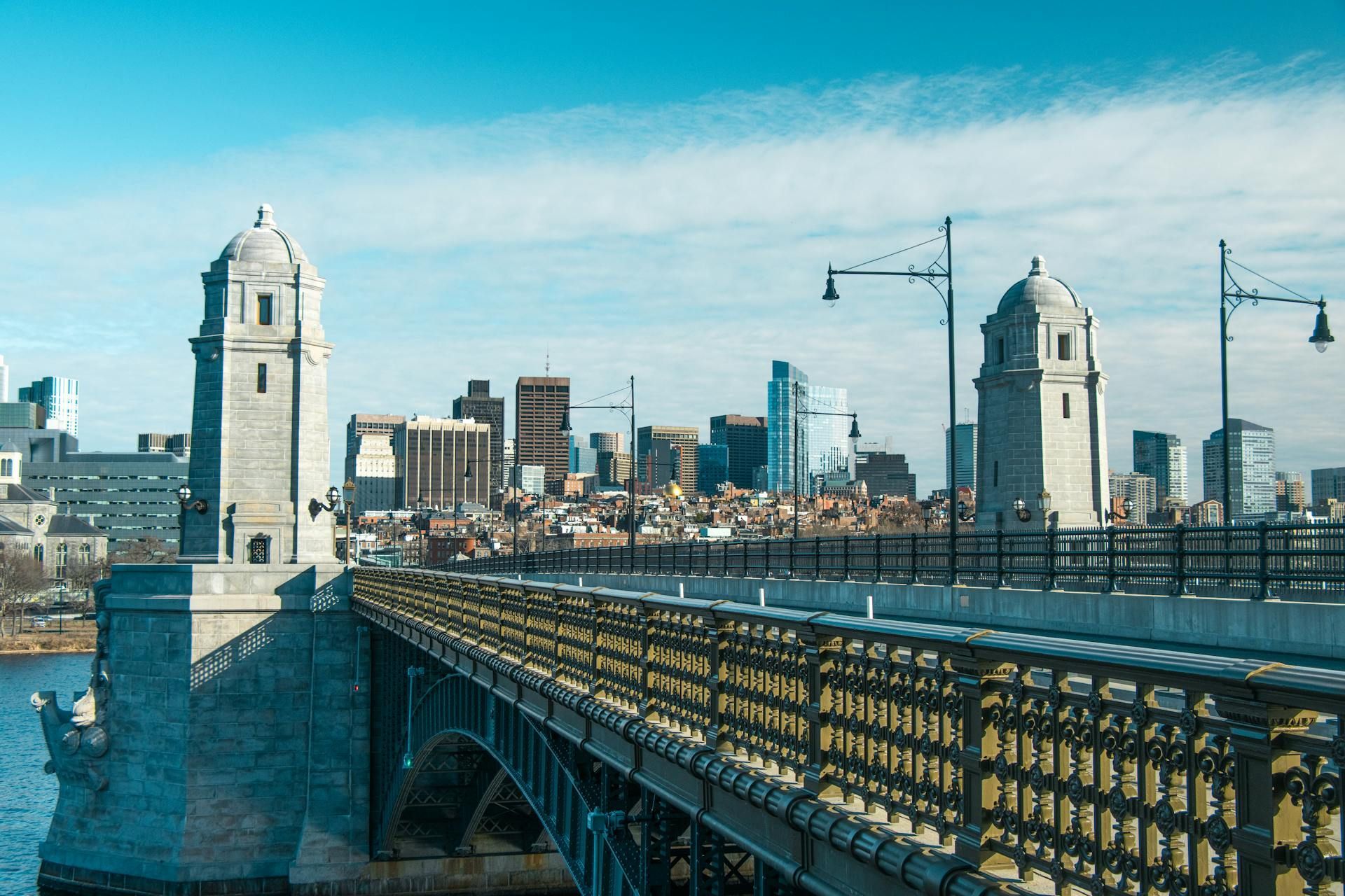 A bridge over a body of water with buildings in the background.