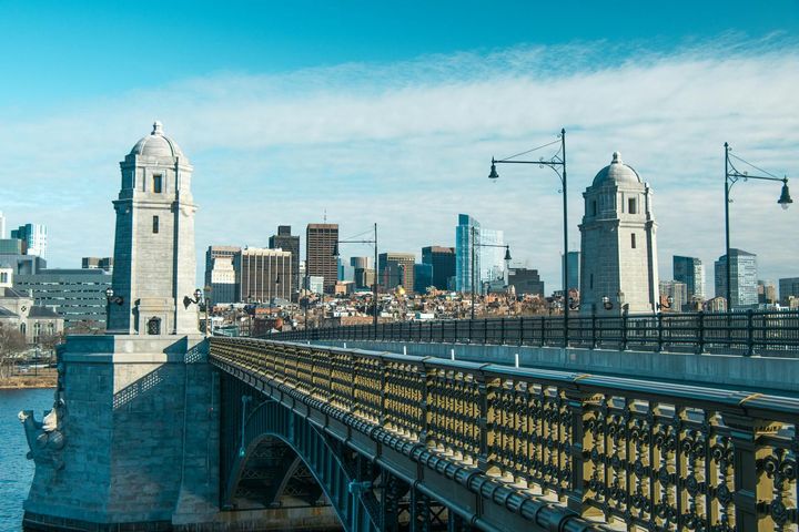 A bridge over a body of water with buildings in the background.