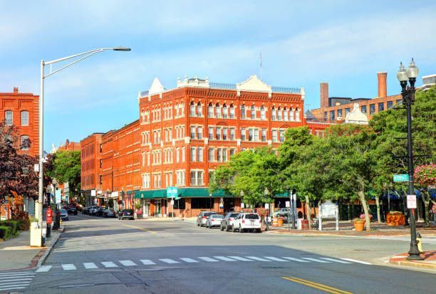 A city street with a large brick building in the background.