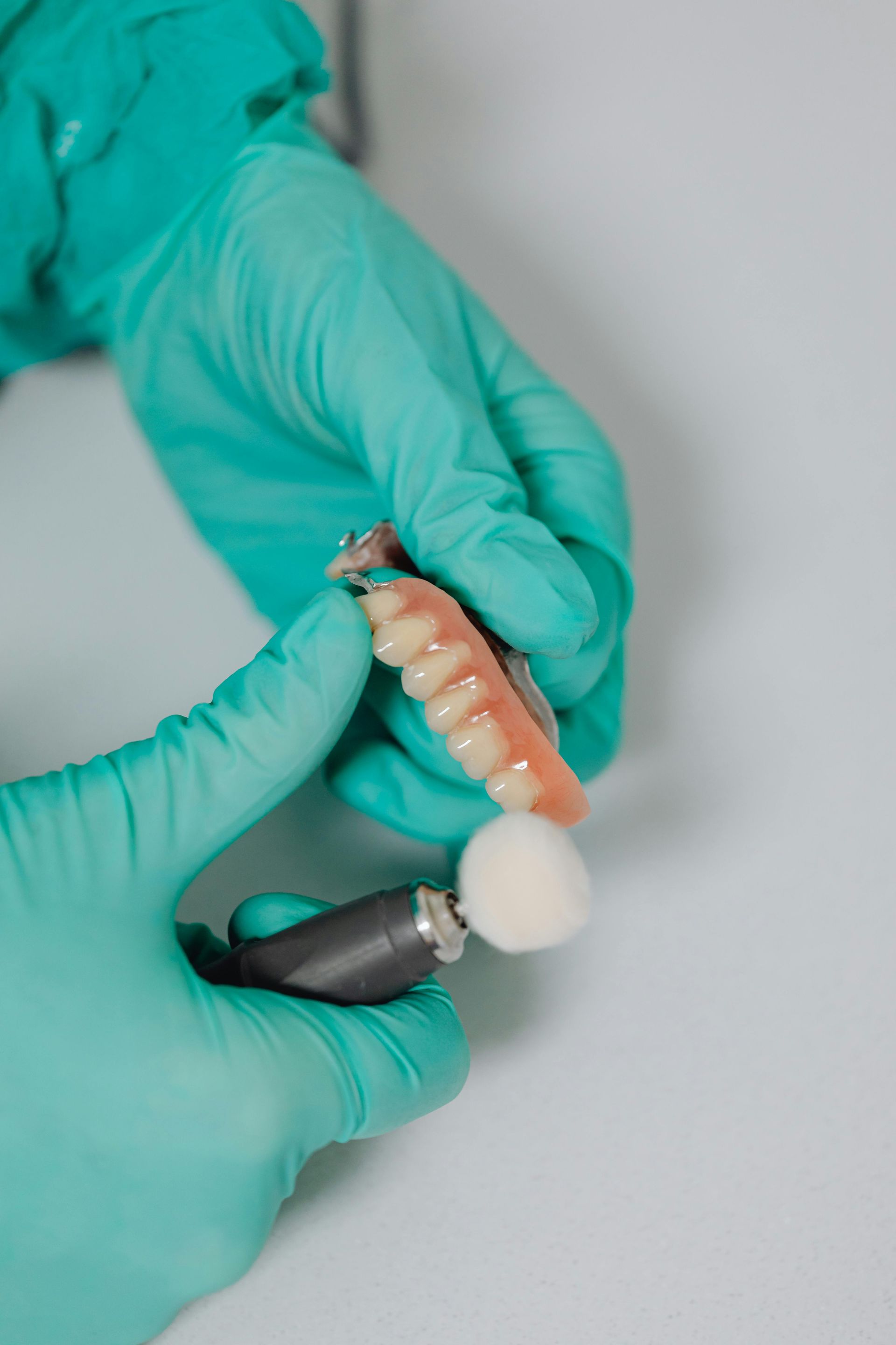 Dentist is Polishing a Denture With a Brush — Cosmetic Denture Services–Jacob Maxwell in Mackay, QLD