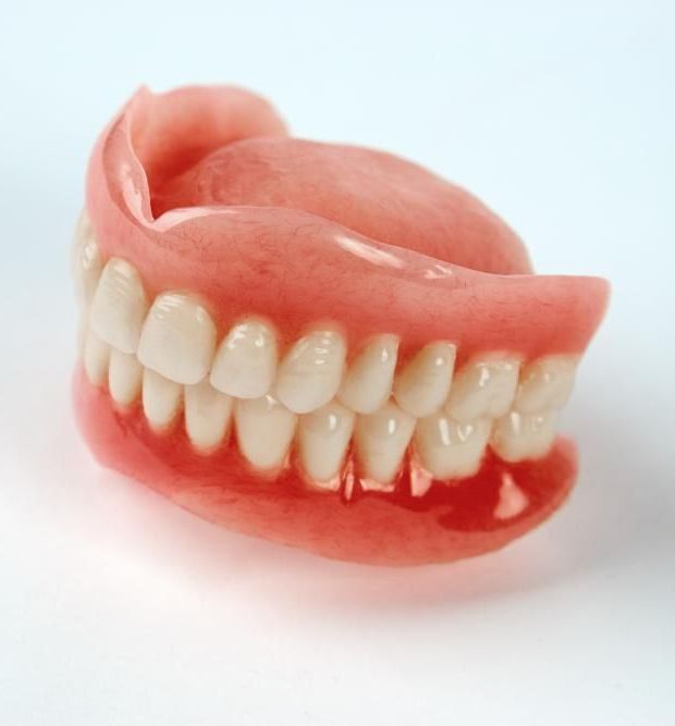 Close Up of a Denture on a White Surface — Cosmetic Denture Services–Jacob Maxwell in Moranbah, QLD