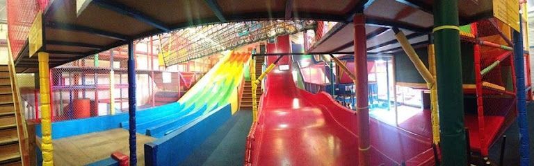 Colorful indoor playground with slides, nets, and climbing structures in a bright play area