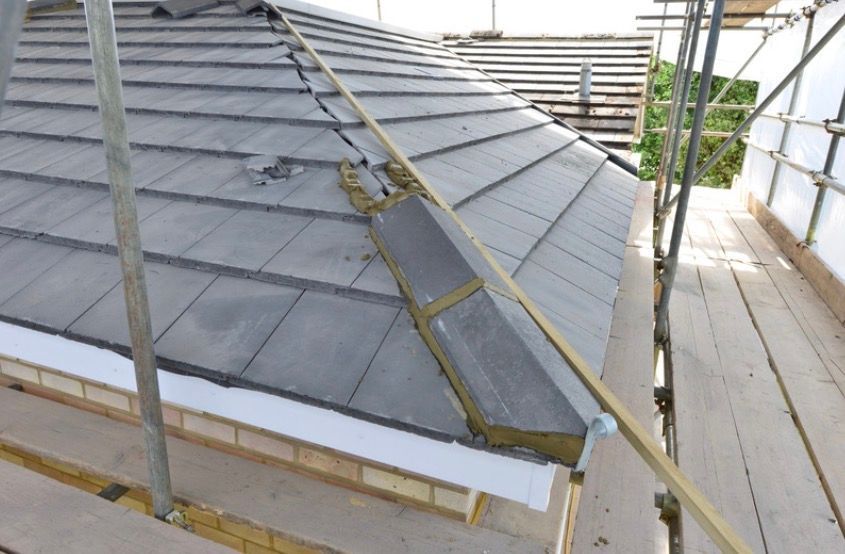 Roof under construction with ladder and scaffolding on a house exterior