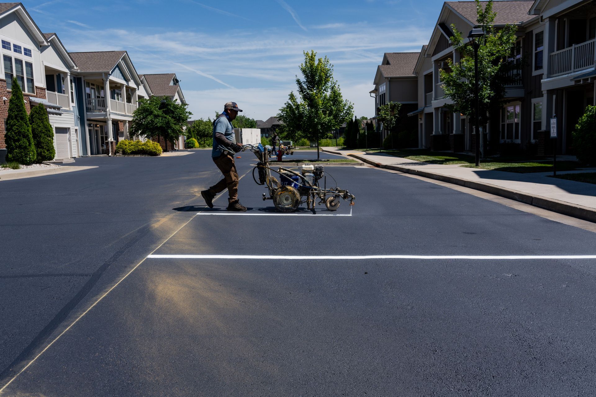 Person pushing a bicycle across a closed street in a residential neighborhood.