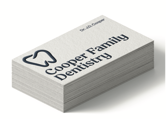 Stack of white business cards for Cooper Family Dentistry with a tooth logo
