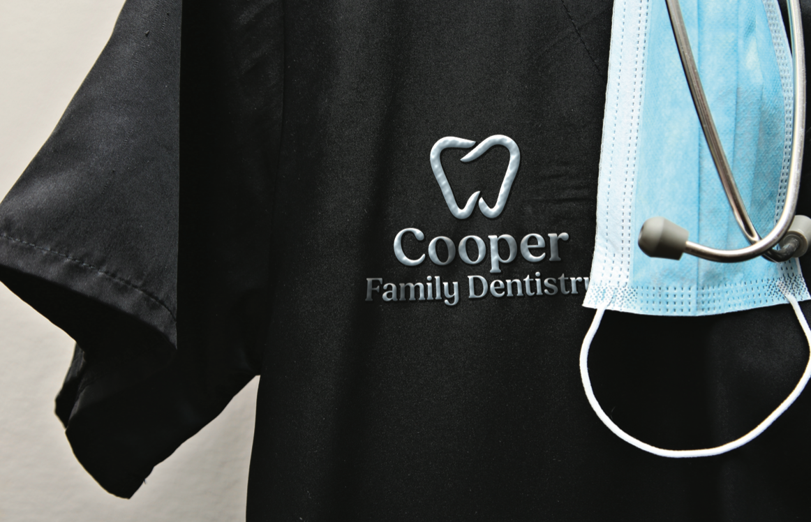Black dental scrub with Cooper Family Dentistry logo and a stethoscope on the right
