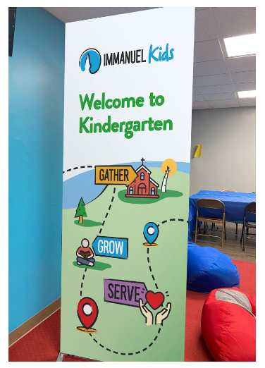 Welcome to Kindergarten sign at Manuel Kids, with colorful path labels in a classroom