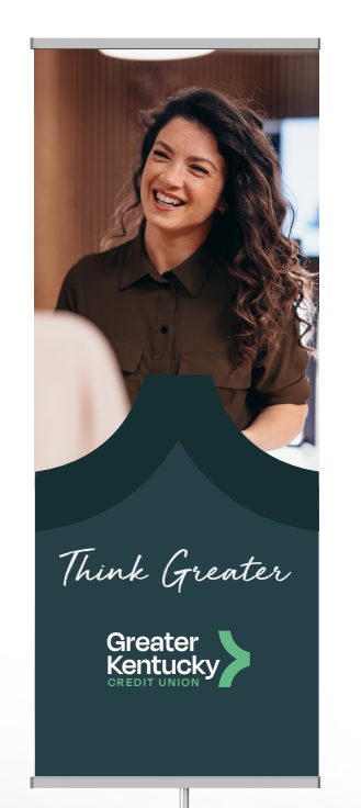 Woman smiling on a Greater Kentucky banner with “Thank Greater” text and green logo on teal background