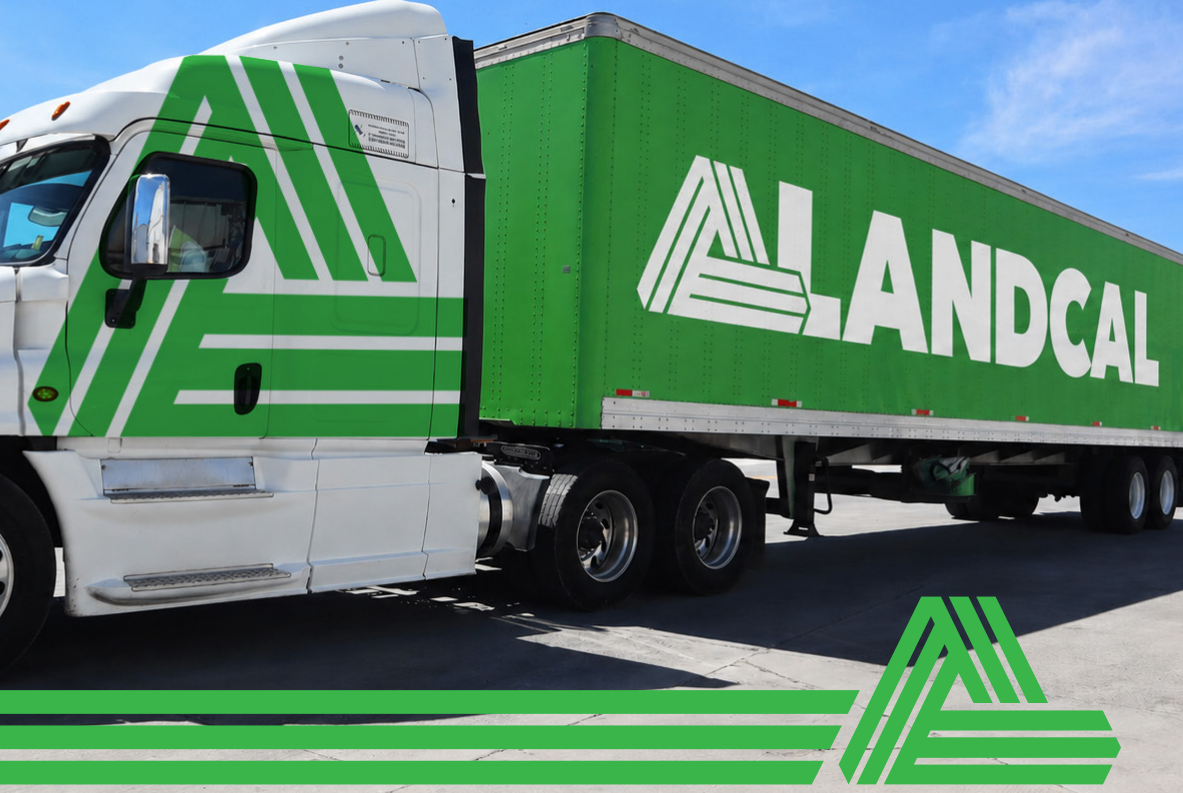 Green and white LANDCAL semi-truck and trailer parked outdoors under a blue sky