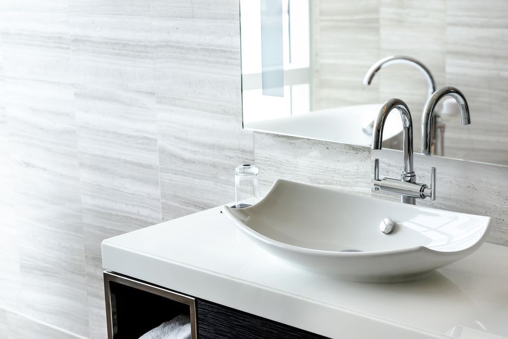A bathroom sink with two faucets and a mirror — Port Stephens Bathrooms In Nelson Bay, NSW