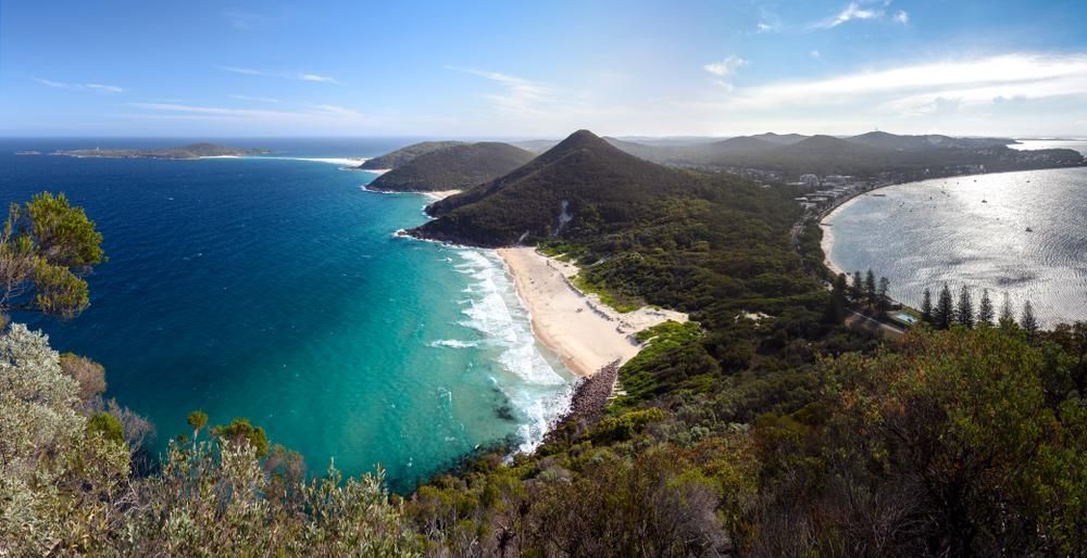 a View of a Beach From a Cliff Overlooking the Ocean — Port Stephens Bathrooms In Nelson Bay, NSW
