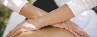 A close up of a person getting a massage with their hands crossed.