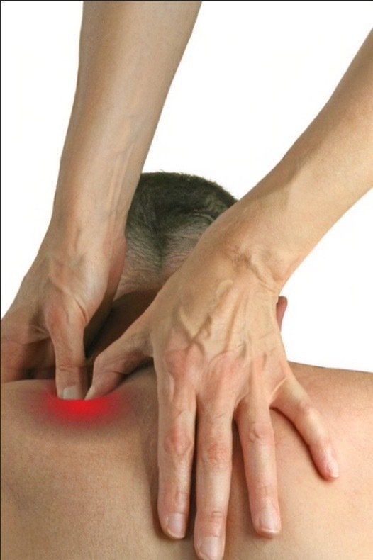 A person is getting a massage with a red spot on their back