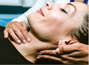 A woman is getting a neck massage from a doctor.