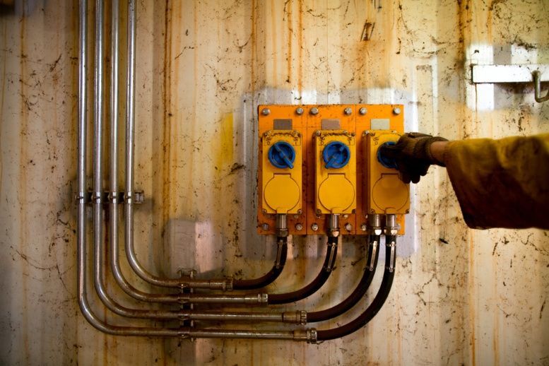 A Person Is Turning A Switch On A Wall — Cool & Secure In Maroochydore, QLD