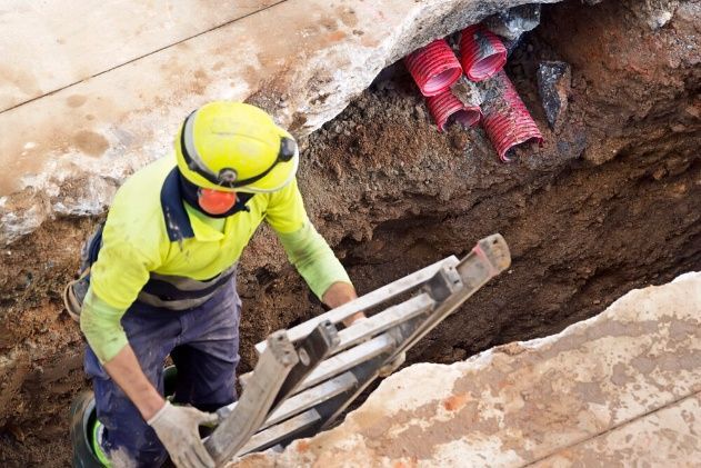 A Man Is Climbing A Ladder Into A Hole In The Ground — Cool & Secure In Maroochydore, QLD