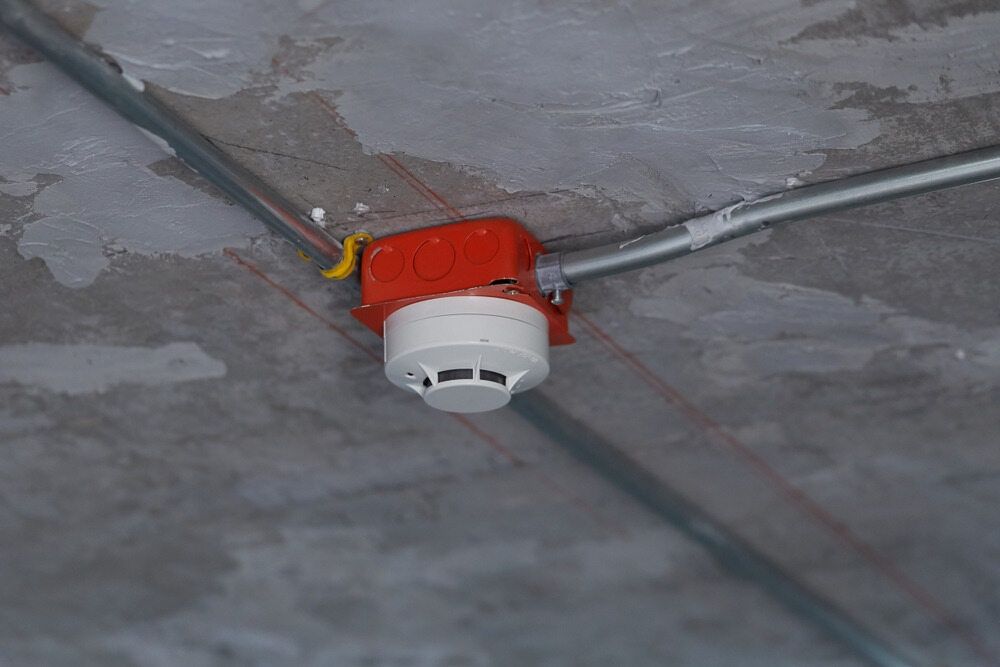 A Smoke Detector Is Attached To The Ceiling Of A Building — Cool & Secure In Noosa, QLD
