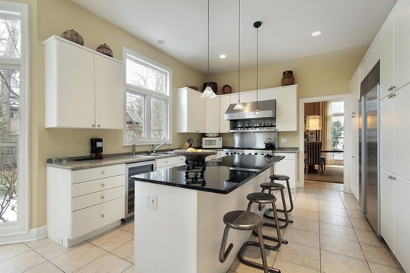 A Kitchen With White Cabinets , Black Counter Tops, Appliances And A Large Island — Cool & Secure In Buderim, QLD