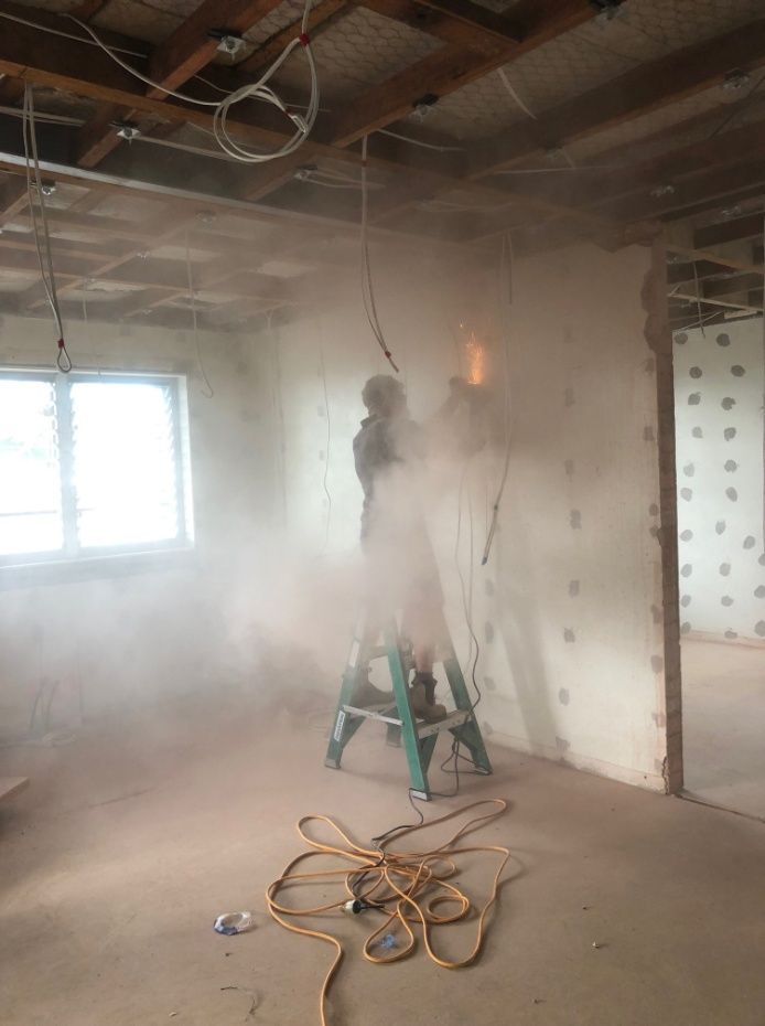 A Man Is Standing On A Ladder In A Room With Smoke Coming Out Of The Ceiling — Cool & Secure In Warana, QLD