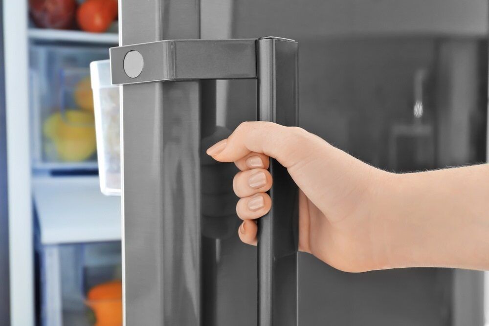 A Person Is Opening A Refrigerator Door With Their Hand — Cool & Secure In Warana, QLD