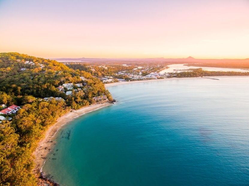 An Aerial View Of A Beach And A Body Of Water At Sunset — Cool & Secure In Noosa, QLD