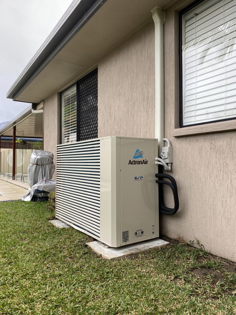 A Man Is Working On An Air Conditioner With A Screwdriver — Cool & Secure In Maroochydore, QLD