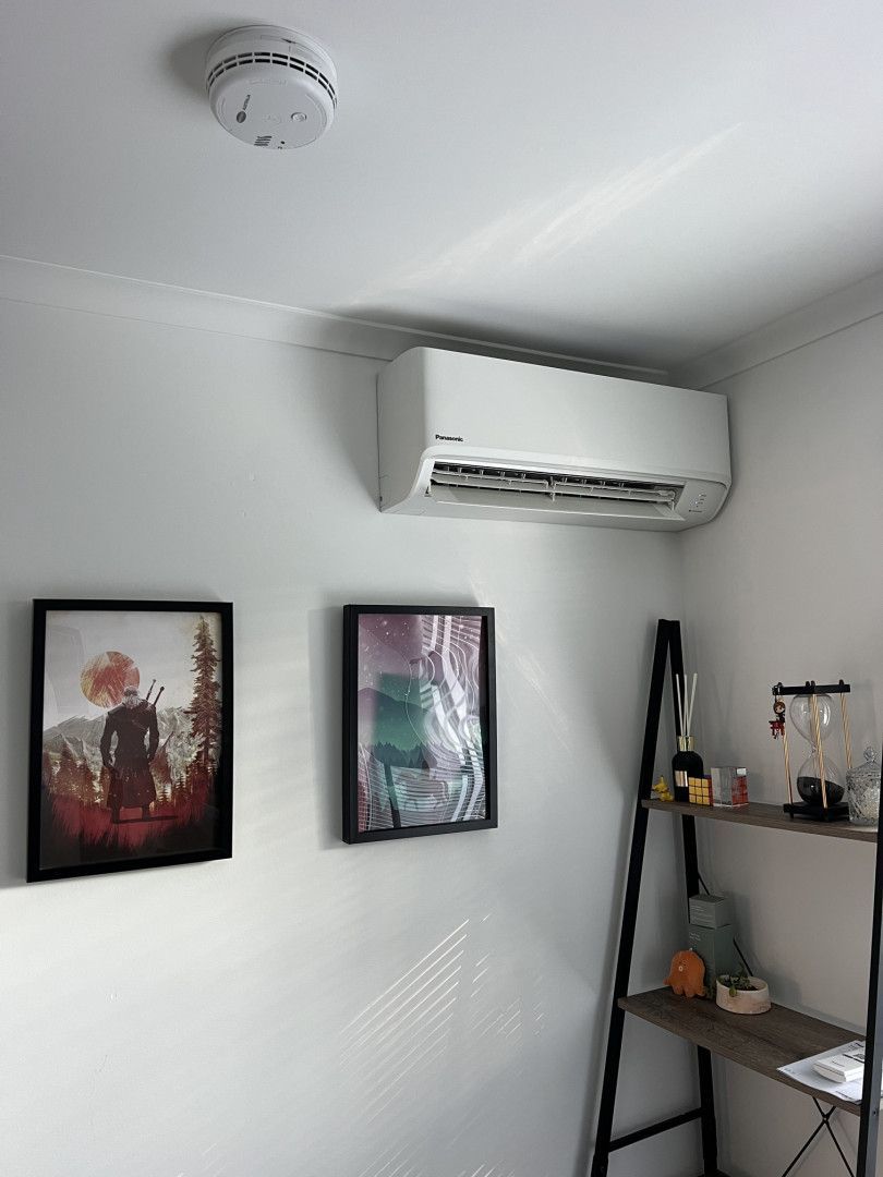 A Man Is Fixing An Air Conditioner With A Wrench — Cool & Secure In Warana, QLD