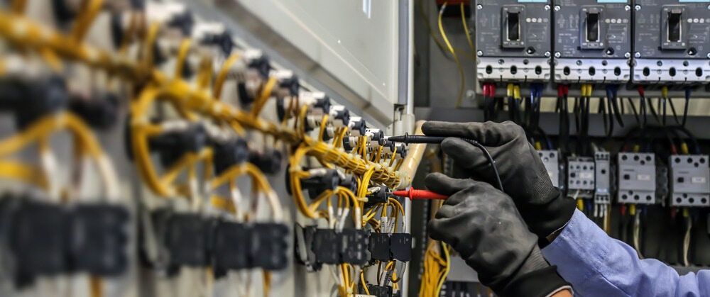 A Man Is Working On An Electrical Box With A Screwdriver — Cool & Secure In Buderim, QLD