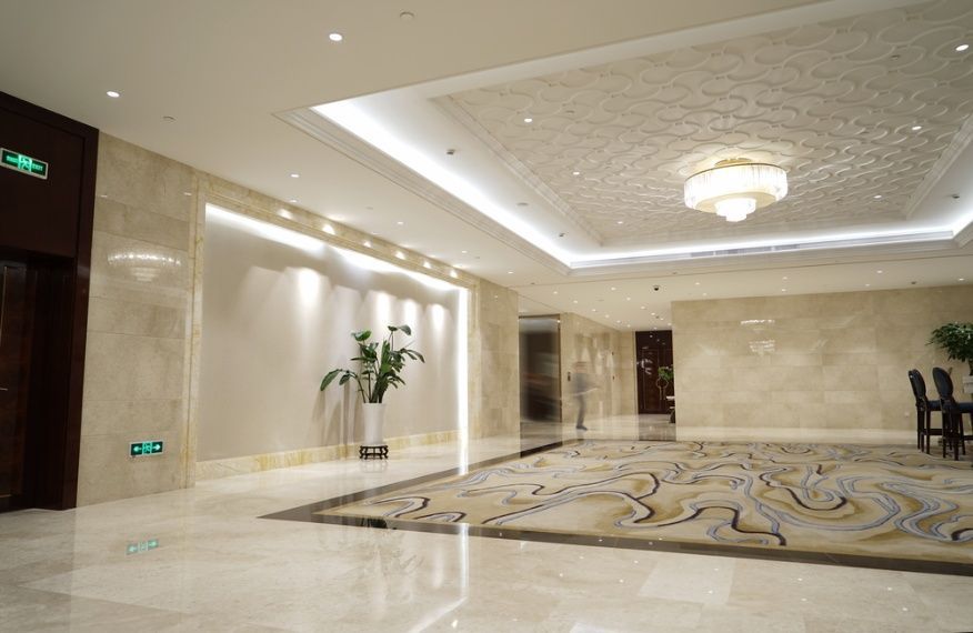 A Large Hallway With A Rug On The Floor And A Chandelier On The Ceiling — Cool & Secure In Noosa, QLD