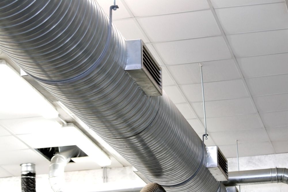 A Large Metal Pipe Is Hanging From The Ceiling Of A Building — Cool & Secure In Noosa, QLD