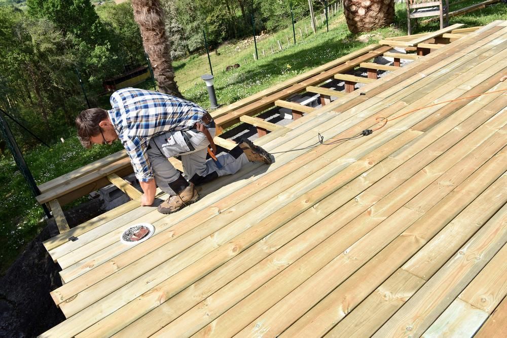 A Man is Working on a Wooden Deck — Lennox Build In Lismore, NSW