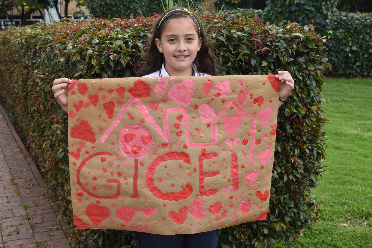 Una persona sostiene un cartel pintado a mano que dice 