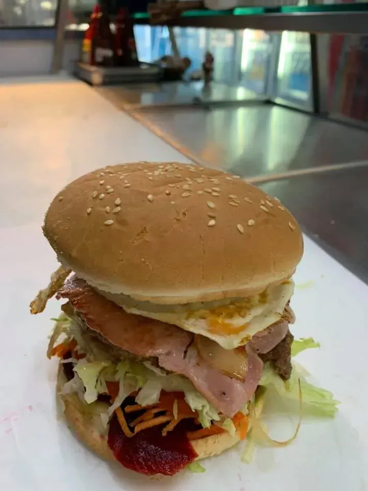A Hot Dog Bun Topped with Melted Cheese and Diced Bacon — Sav's Takeaway In Mount Isa, QLD