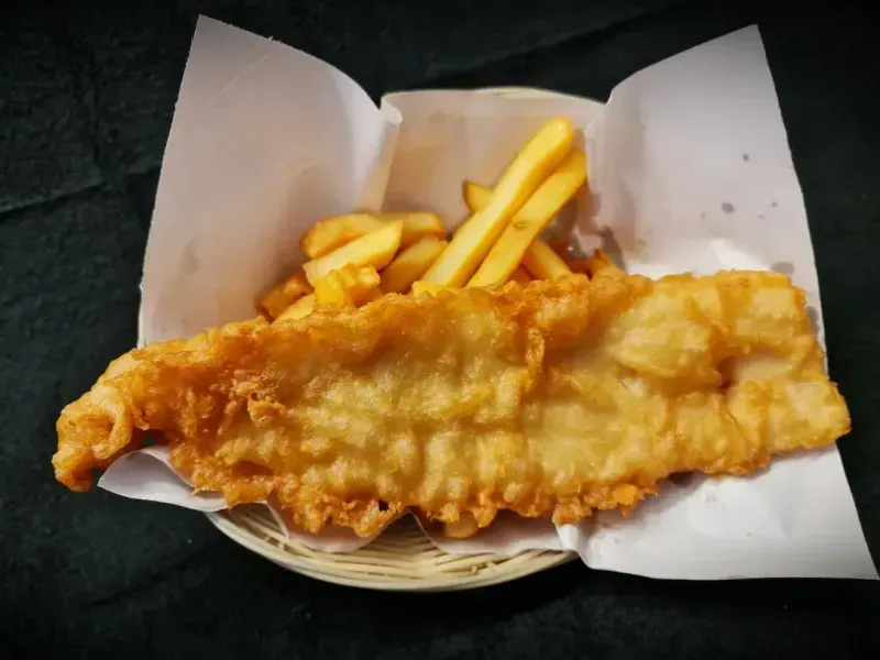 A Golden-Brown Battered Fish Fillet Served with A Portion of Crispy Fries — Sav's Takeaway In Mount Isa, QLD