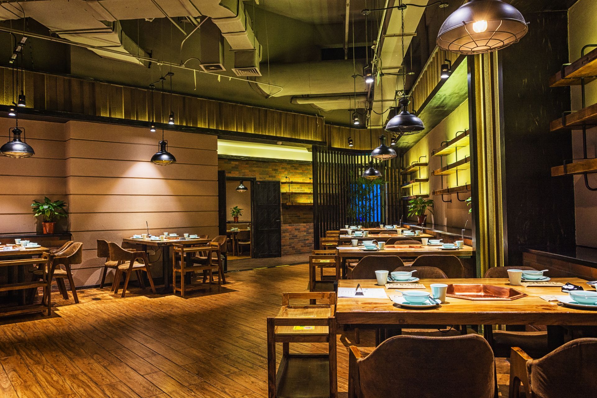 A restaurant with tables and chairs and a wooden floor.