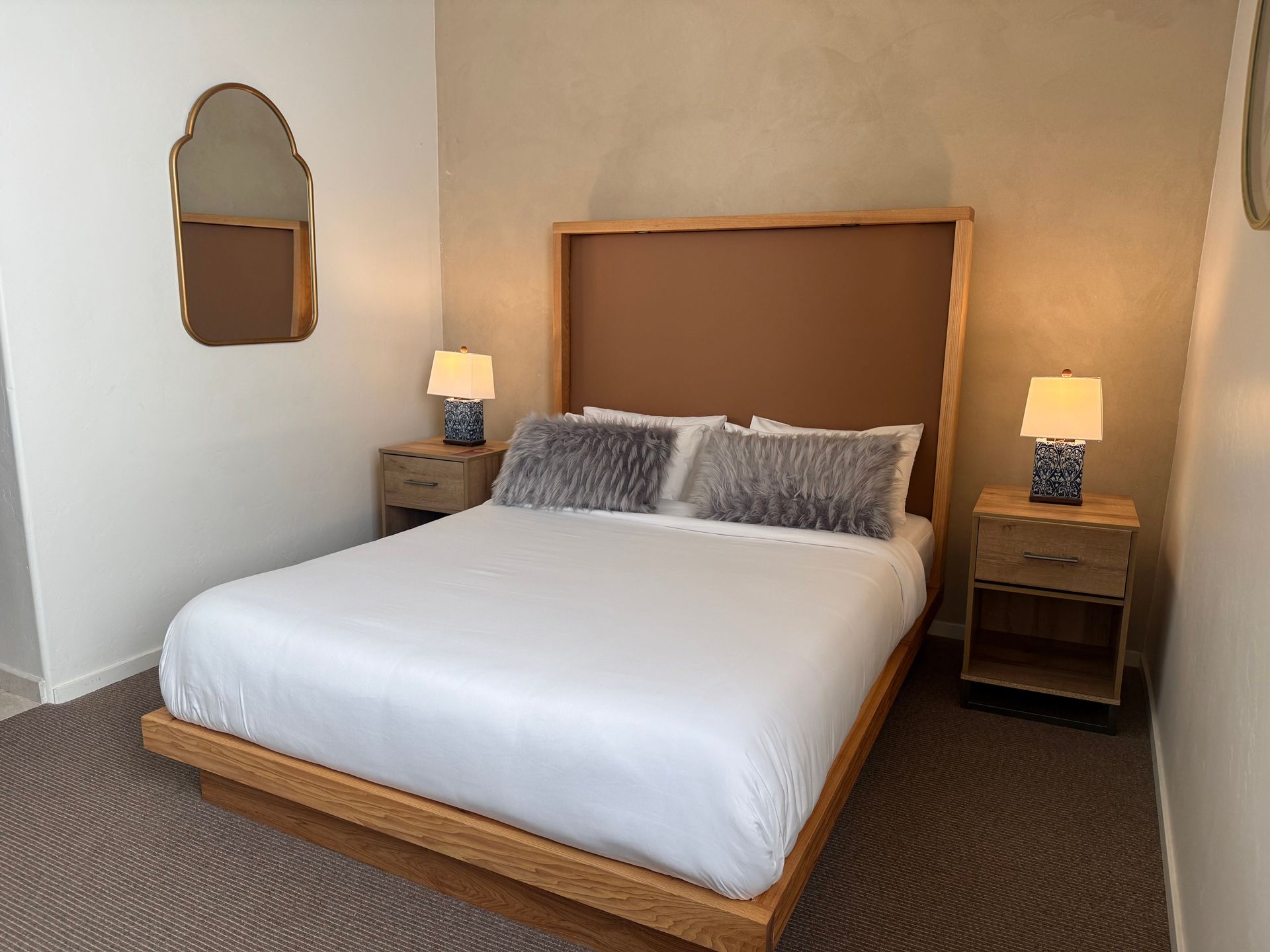 Bedroom with a bed, blue armchair, round wooden coffee table, and a wall clock.
