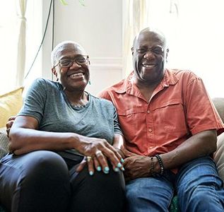 Smiling couple sitting on a couch in a bright living room