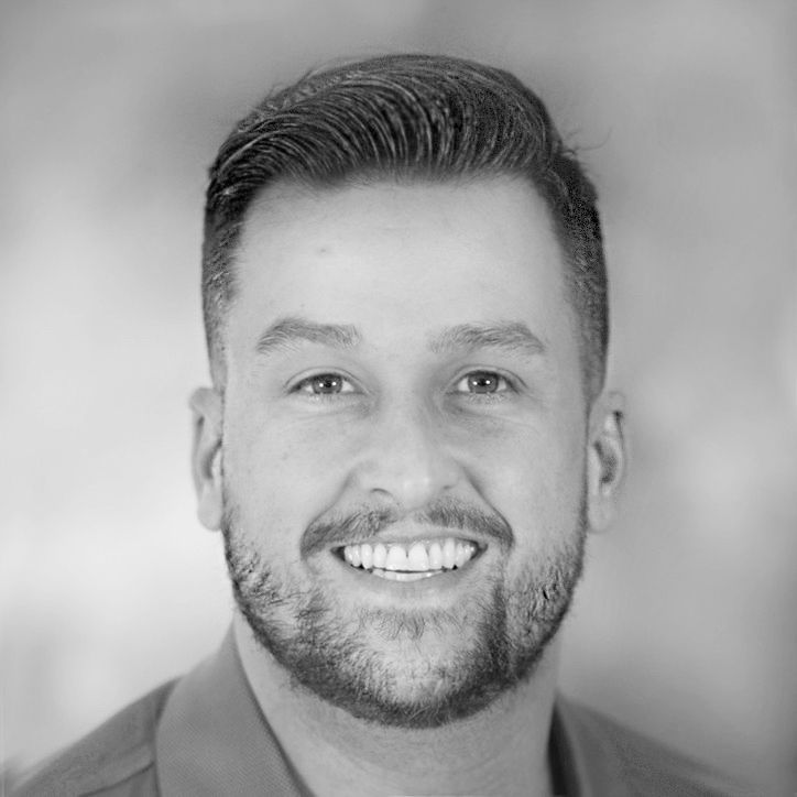 Man with short dark hair and beard smiles broadly.