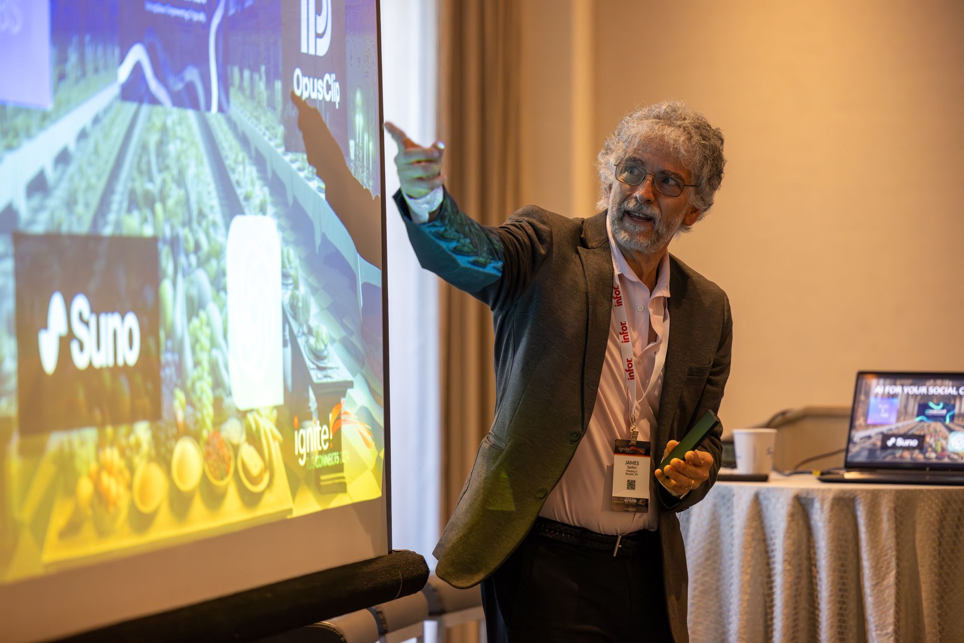 Man gesturing at a presentation screen during a conference.