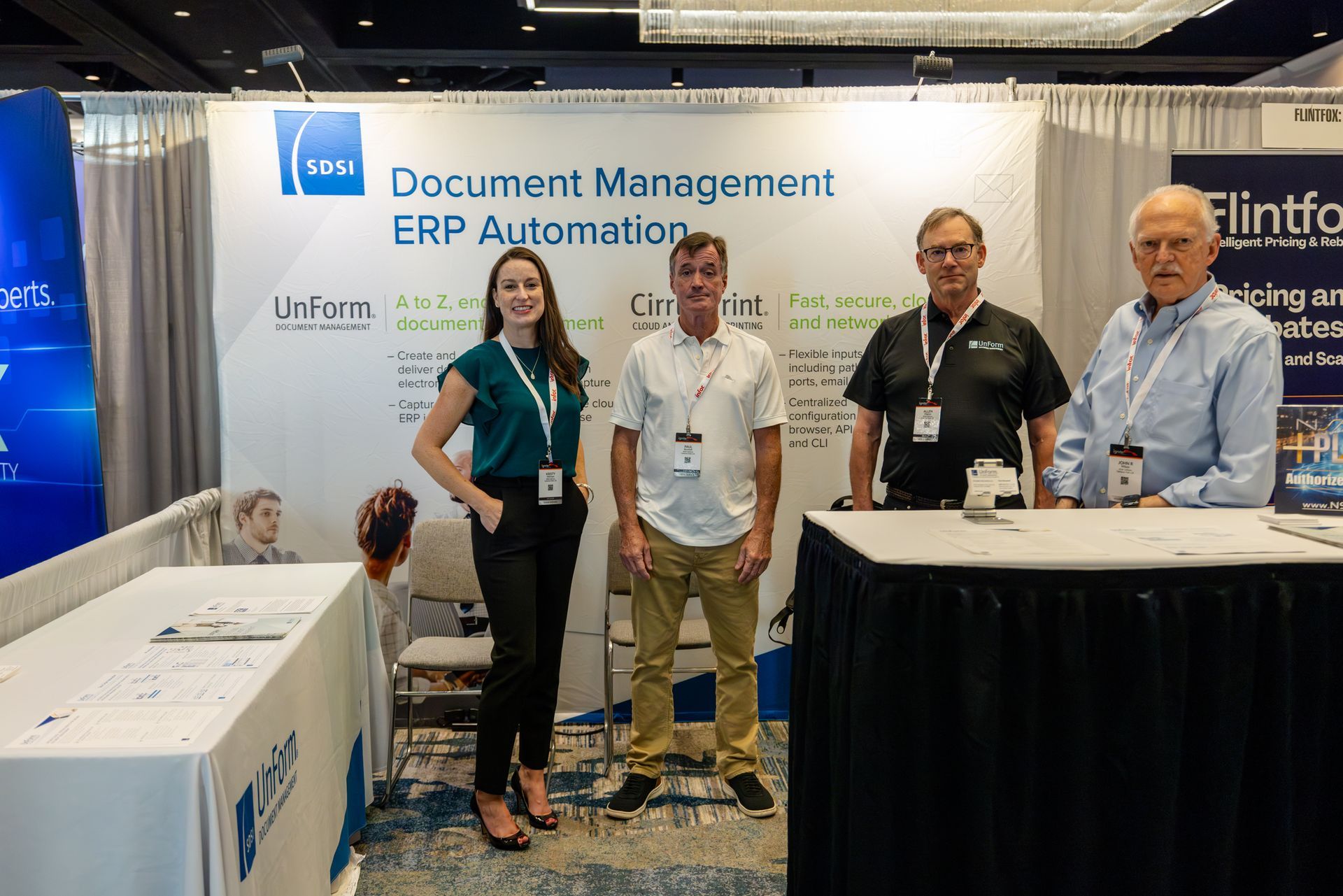 Four people stand in front of a trade show booth with 