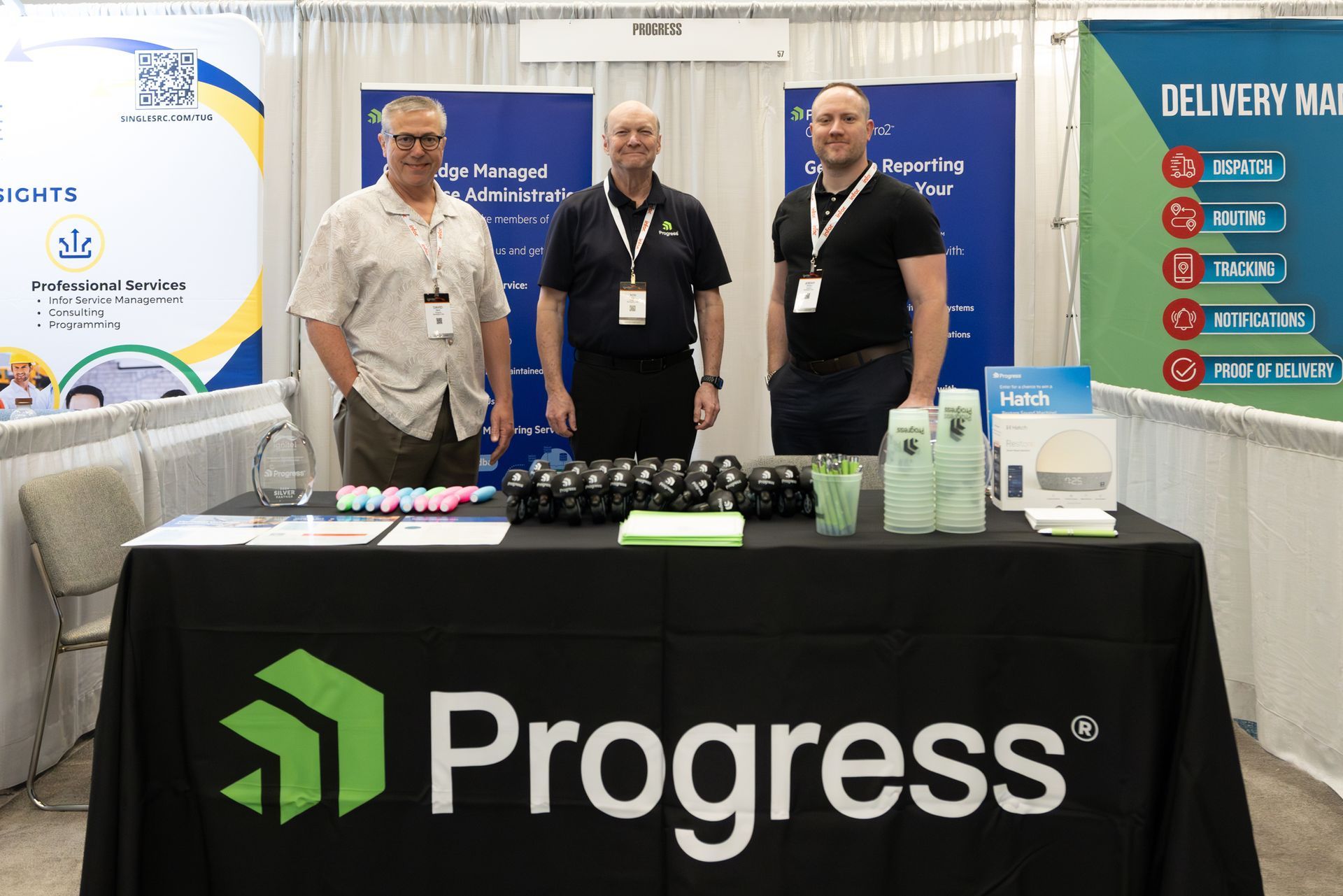 Three men at a trade show booth with 
