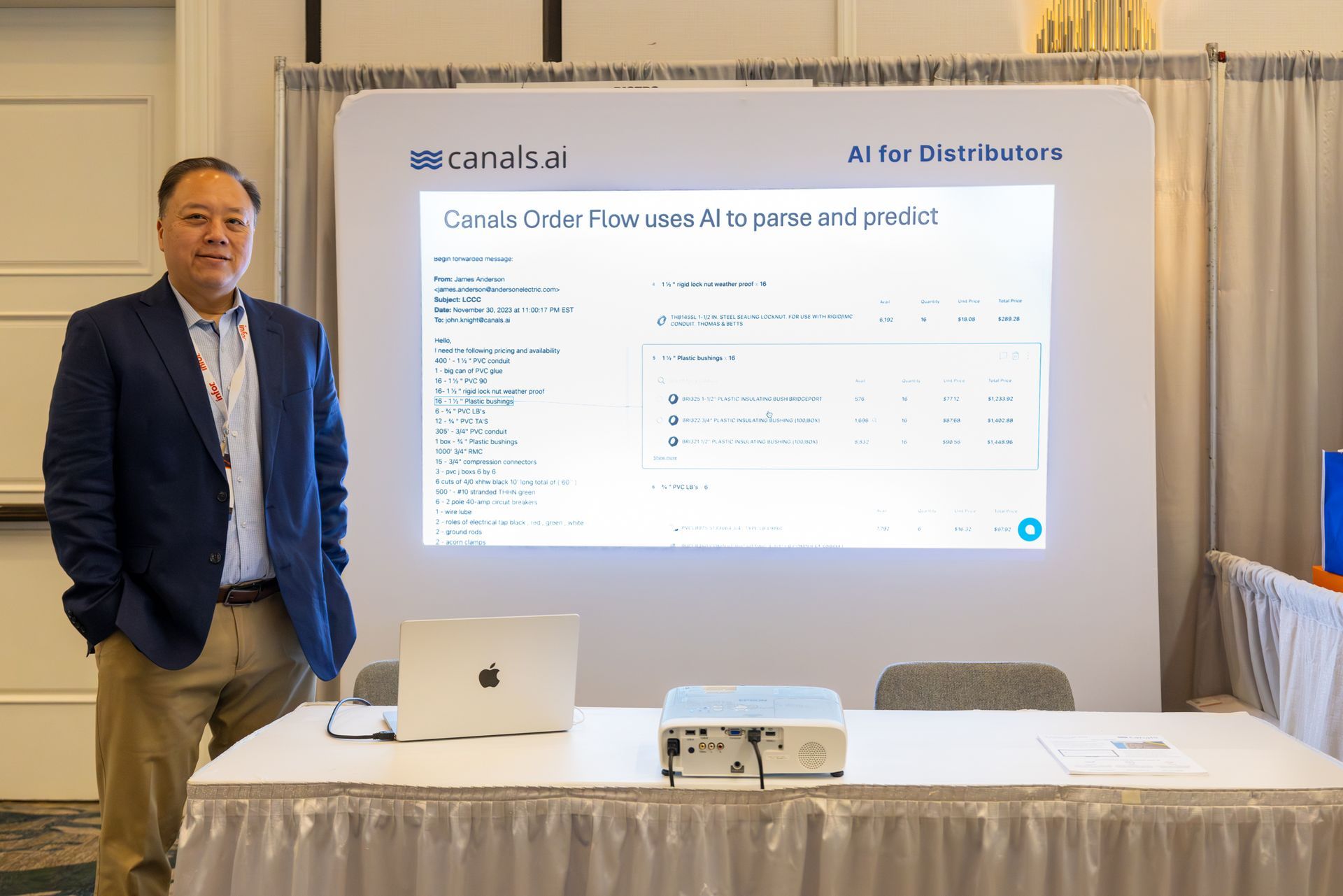 Man stands by a presentation screen; 
