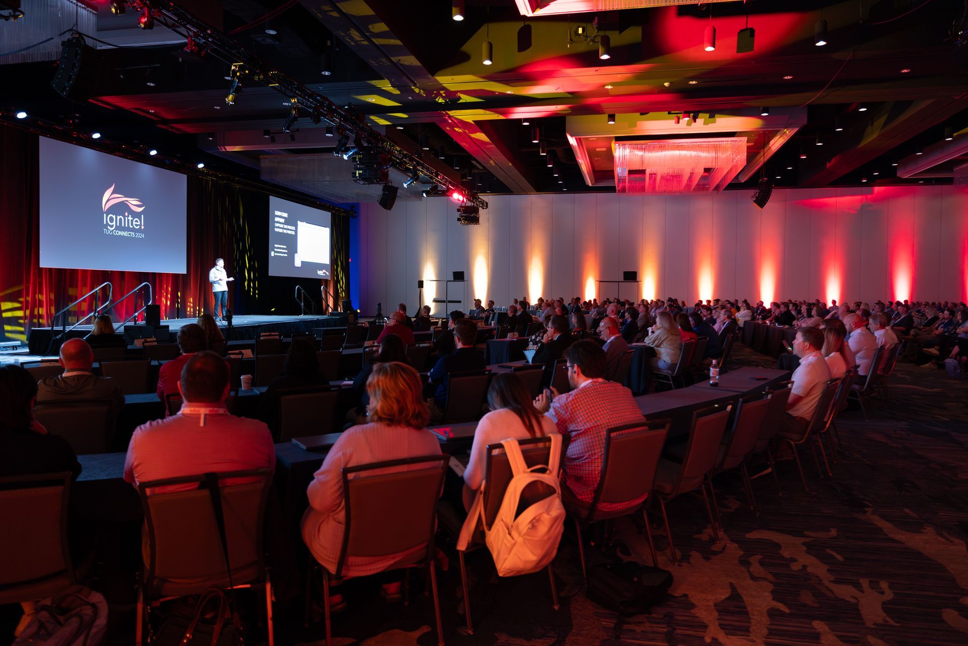 Conference presentation in a large hall with an audience.