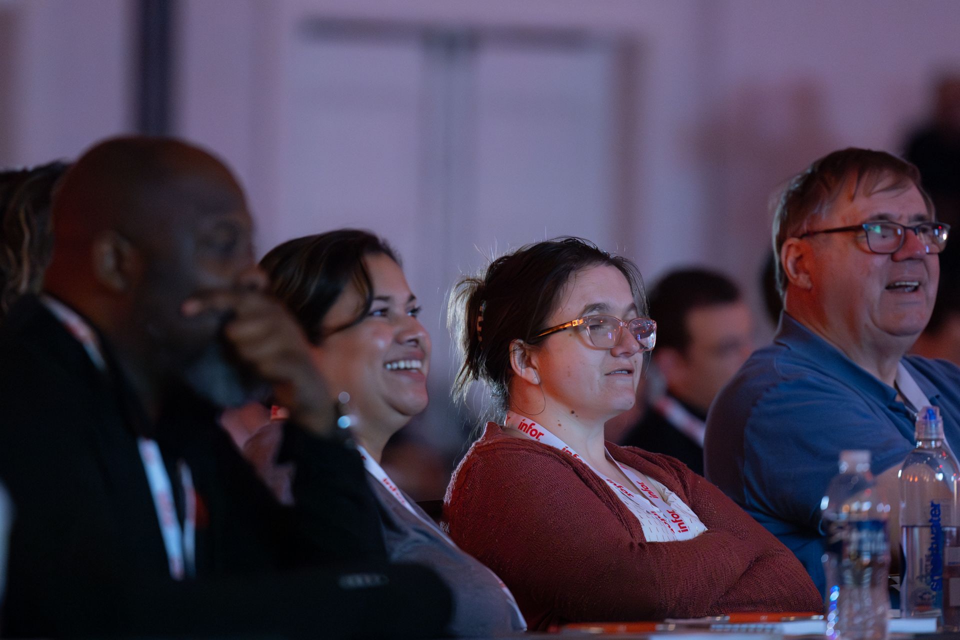 Audience members seated at a conference, looking toward the speaker.