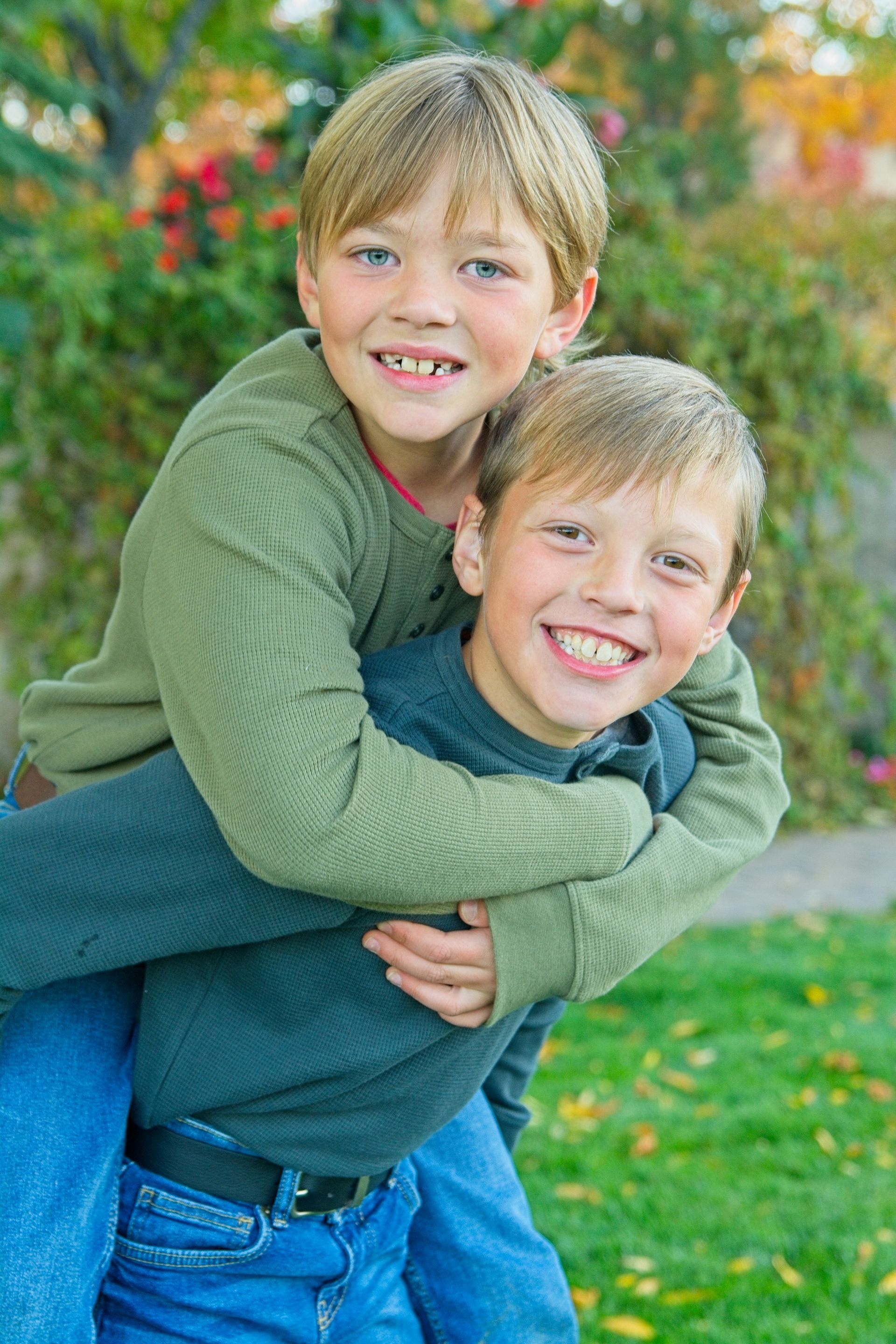 A man is carrying two young boys on his back.